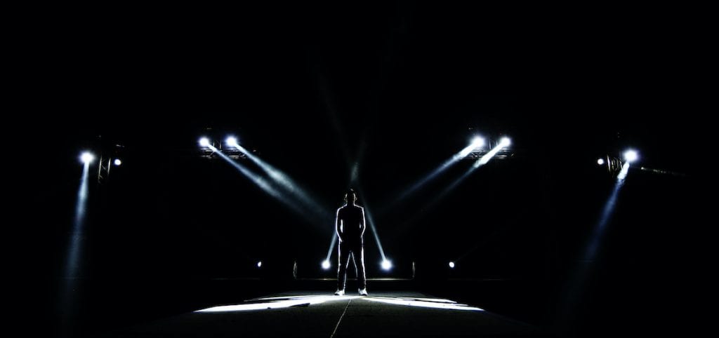 Men standing in the light on a stage