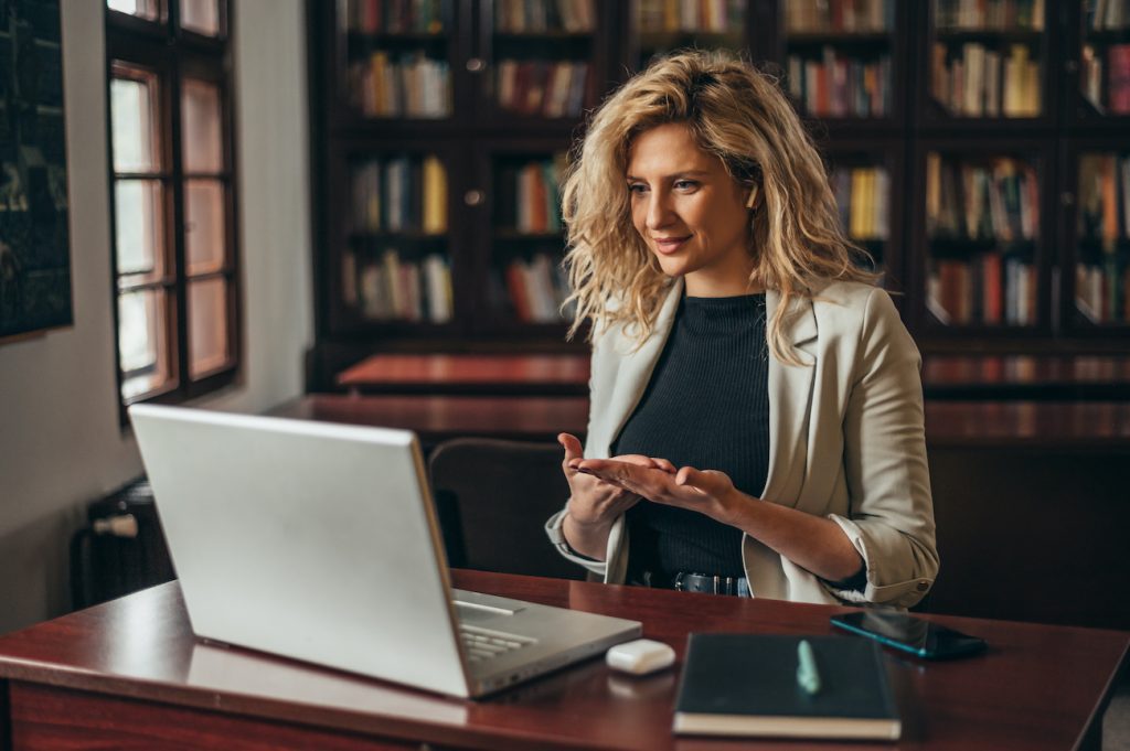 Young beautiful blonde businesswoman using a laptop for an online meeting while working in the office